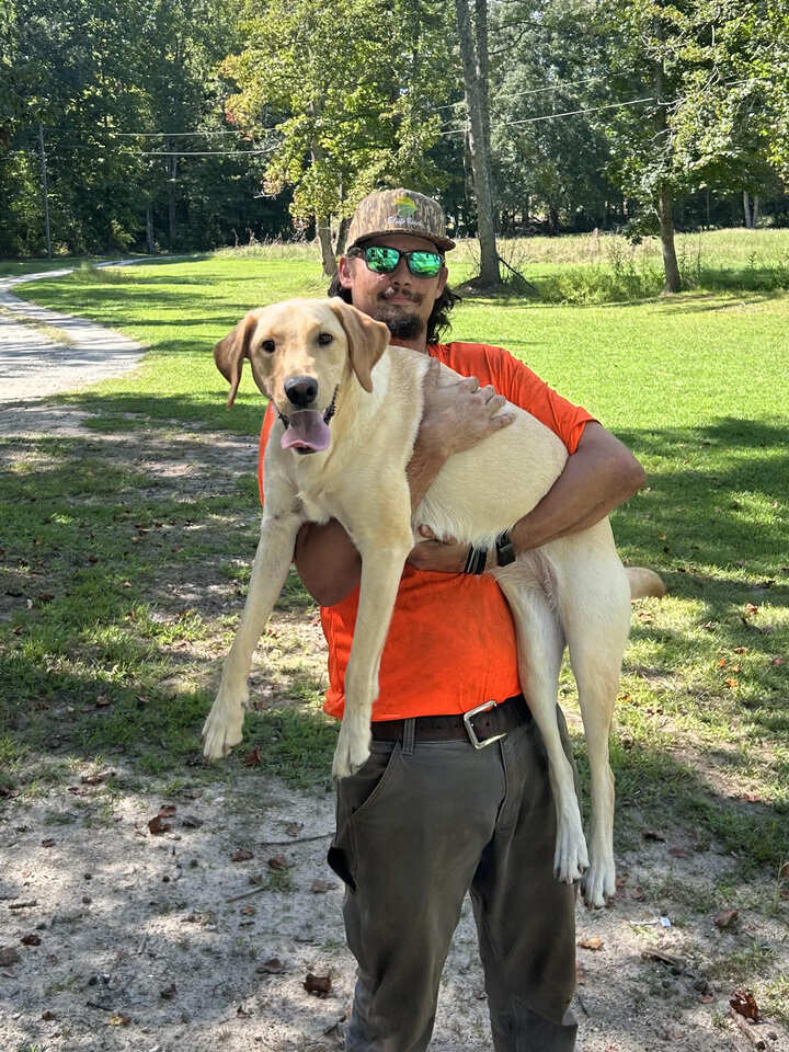 Wyatt Dodgens, owner and operator, holding his dog